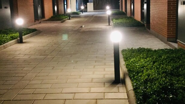 A nighttime view of a brick building with a paved walkway and illuminated bollards. - semi-detached house with pool 3 bedrooms near the beach (Platja d'Aro)