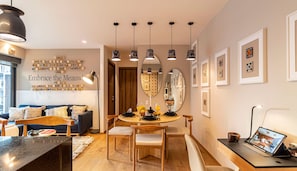 Relax in a stylish space with a sofa, dining table, and desk, perfect for work or leisure.