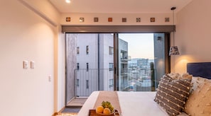 Relax on the large bed and enjoy the city view from the balcony with sliding glass door.