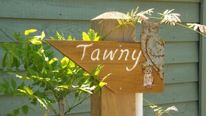 A wooden sign with the name 'Tawny' and an owl illustration. - Tawny (Crediton)