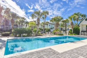 Relax by the pool surrounded by palm trees and a scenic view.