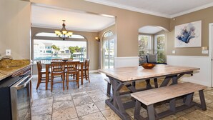 Una cocina con una mesa de comedor, sillas y vistas a una piscina.