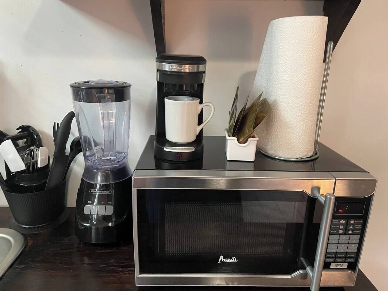 A kitchen with a blender, coffee maker, and microwave.