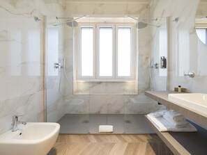 Habitación cuádruple Deluxe | Baño | Regadera, regadera tipo lluvia, amenidades de baño de diseñador 