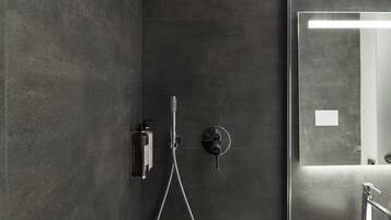 Een moderne badkamer met een douche, wastafel en spiegel.