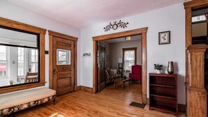 A wooden-floored hallway with a bench, a door, and a mirror. - Kent Family Home | Walk to Downtown + Pet Friendly (Kent)