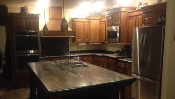 A kitchen with wooden cabinets, stainless steel appliances, and a marble countertop. - motor home (Columbia)