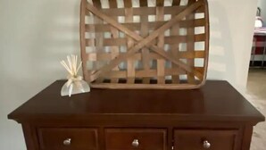 A dark wooden desk with three drawers, a decorative tray on top, and a pink cloth on the lower shelf. - The Old Farmhouse. (Dry Ridge)