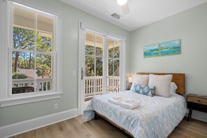 Une chambre à coucher avec un lit, une table de chevet et un tableau accroché au mur.