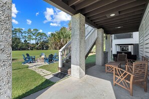 A covered outdoor seating area with stone pillars, a fire pit, and a grill. - Bonito Bliss - Golf Cart Included! 722 Bonito (Fripp Island)