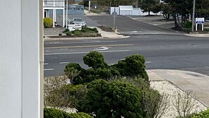 A view of a street with a building on the left, a parking lot, and a sign that reads "Ocean Front." - Brigantine dream home just steps to the beach! (Brigantine)