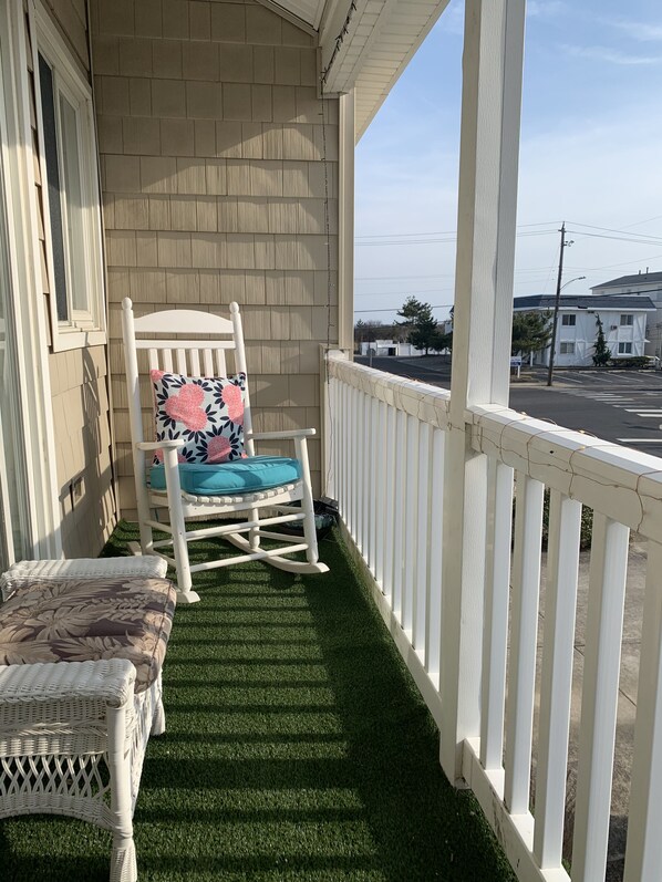 A porch with a rocking chair and a bench, both with floral cushions. - Brigantine dream home just steps to the beach! (Brigantine)