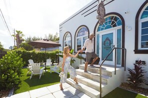 Entrada de hotel con una escalera, una estatua de Buda y asientos al aire libre.
