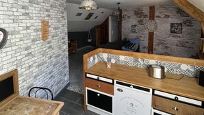 Una cocina con pared de ladrillo, mostrador de madera y una lámpara colgante.