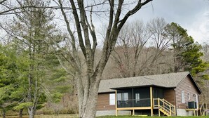 A lodge with a large porch and a staircase leading to the entrance. - Outdoorsman Paradise (Wolf Lake)