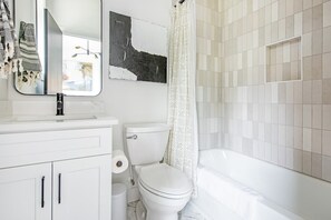 Bathtub, hair dryer, towels, shampoo