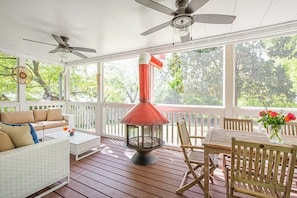 A covered porch with a wood-burning stove, seating area, and ceiling fans. - Cherry Cola (Atlanta)