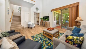 A spacious living room with a staircase, a sofa set, a coffee table, and a television. - Includes Mauna Lani Beach Pass.  101 Kulalani (Mauna Lani Resort)