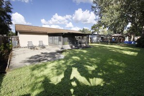 Enjoy a serene backyard retreat with a covered patio, lush lawn, and a swing set.