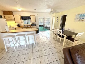 Efficient kitchen and dining space with a central island, sink, and microwave, perfect for meals and everyday use.