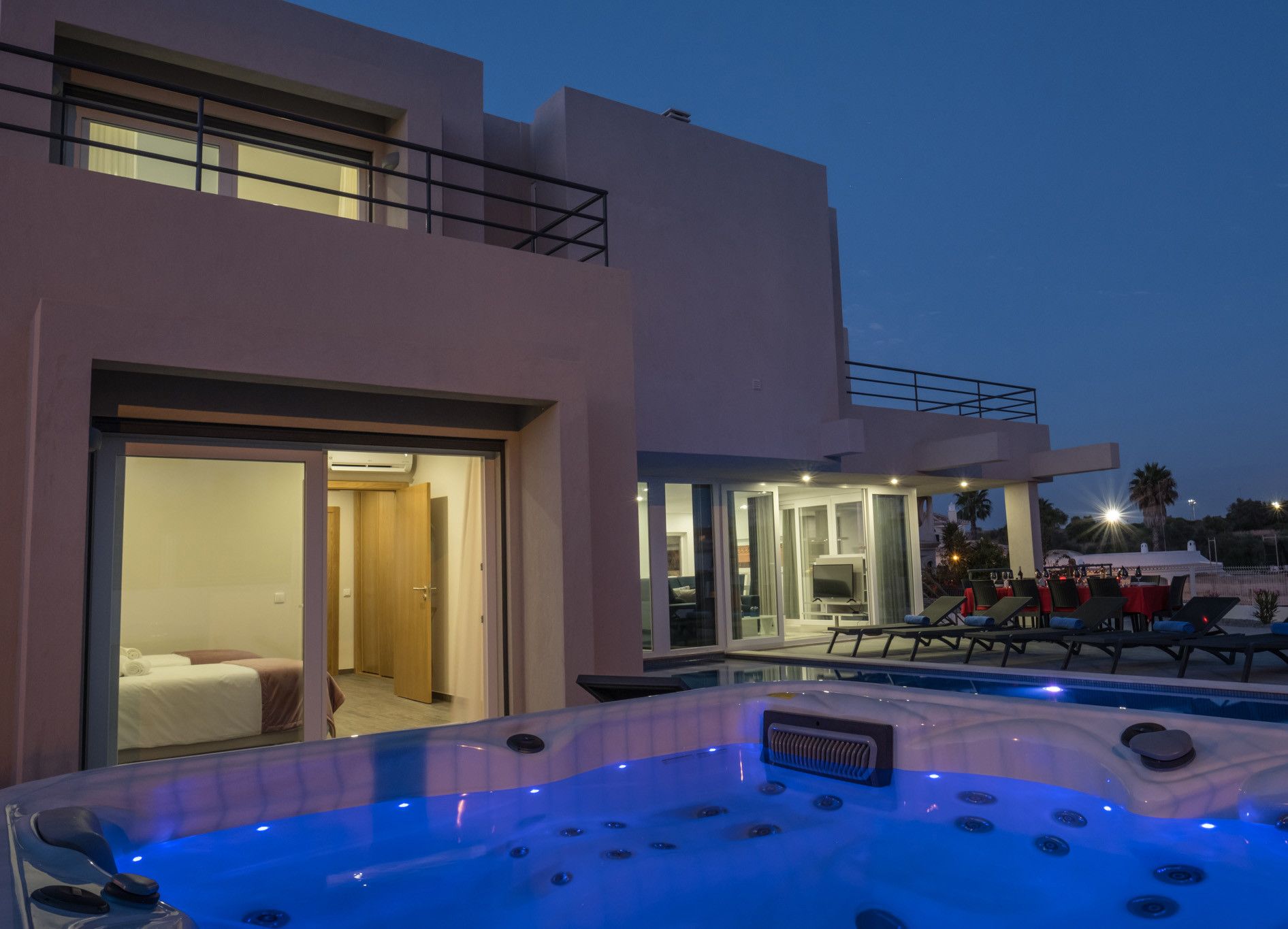 Un hôtel moderne doté d’un espace piscine, comprenant un jacuzzi et des chaises longues.