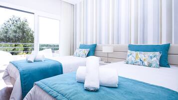 A hotel room with two beds, a balcony view, and a modern design.
