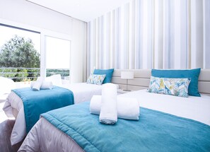 Camera d'albergo con due letti, vista dal balcone e arredamento moderno.