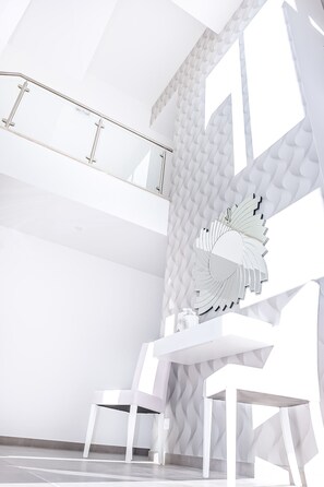 A modern interior with a white color scheme, featuring a unique wall design and a central decorative element resembling a fan or flower. - Luxury Villa w/ Jacuzzi and Heatable Pool (Armação de Pêra)