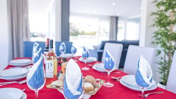 A dining area with tables set for a meal, featuring blue napkins and white plates.