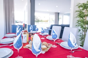 A dining area with tables set for a meal, featuring blue napkins and white plates.