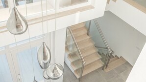 A modern interior with a staircase, hanging pendant lights, and a view of the outdoors. - Luxury Villa w/ Jacuzzi and Heatable Pool (Armação de Pêra)