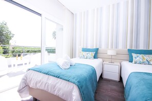 A hotel room with two beds, a balcony, and a view of greenery. - Luxury Villa w/ Jacuzzi and Heatable Pool (Armação de Pêra)