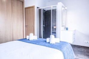 A hotel room with a bed, a shower area, and a white dresser. - Luxury Villa w/ Jacuzzi and Heatable Pool (Armação de Pêra)