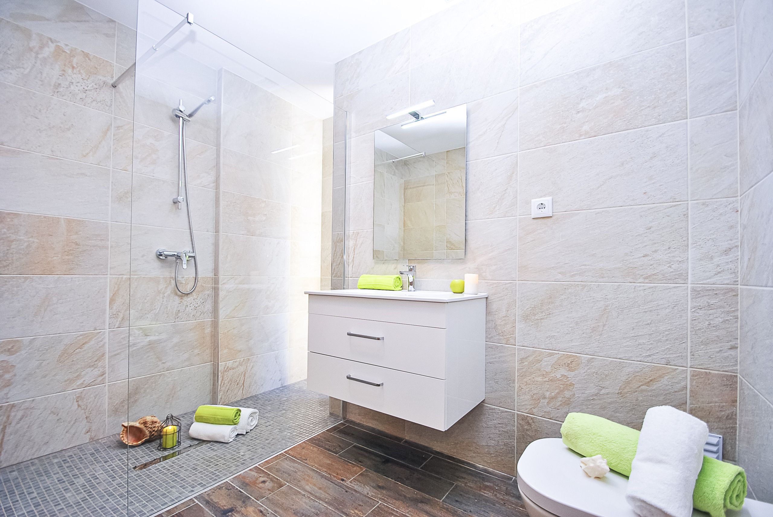 A modern bathroom with a shower, a sink, and a toilet.