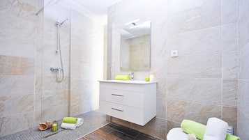 A modern bathroom with a shower, a sink, and a toilet.