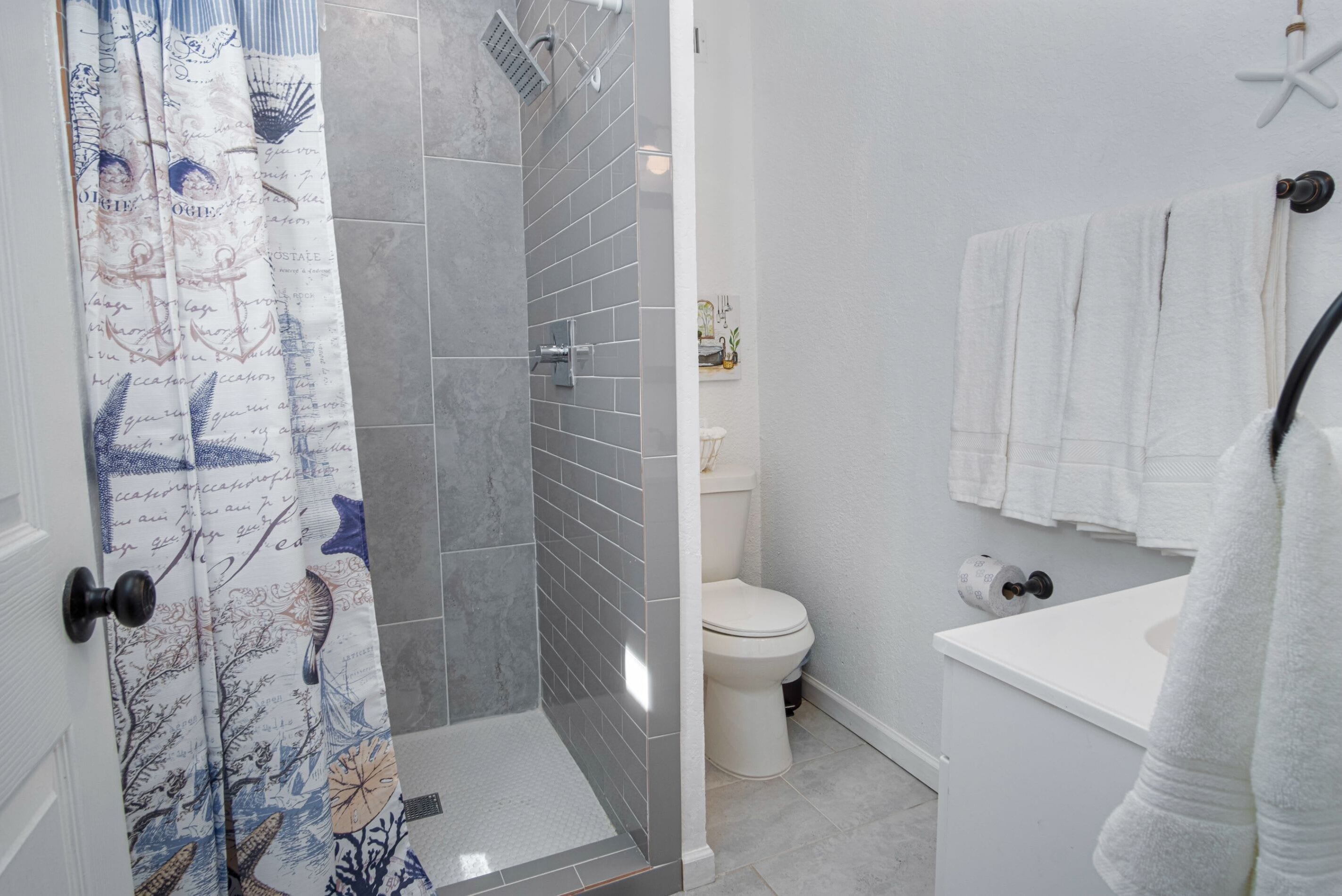 A bathroom with a shower, toilet, and sink.