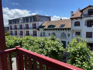 Une rangée de bâtiments de style européen traditionnel, dotés de nombreuses fenêtres et de balcons, et entourés d’une végétation luxuriante.