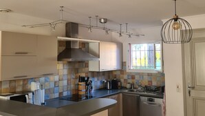Una cucina moderna con un'isola centrale, elettrodomestici in acciaio inossidabile e diversi utensili.