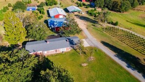 An aerial view of a rural property with a main house, a barn, and a vineyard.