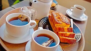 A tray with two cups of coffee, a teapot, a teacup, and a pastry on a wooden table. - City inn hotel  (Cairo)