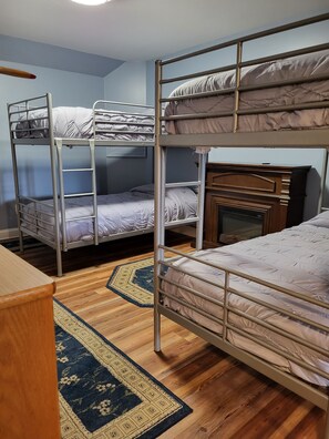 A dormitory room with bunk beds, a wooden dresser, and a small fireplace. - Beautiful waterfront lodge, private dock and breath taking views of Smith Mt. (Pittsville)