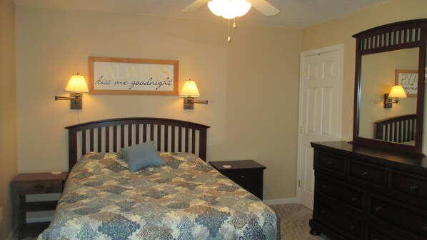 A bedroom with a bed, two bedside lamps, a nightstand, a dresser, a mirror, and a ceiling fan. - Beautiful waterfront lodge, private dock and breath taking views of Smith Mt. (Pittsville)