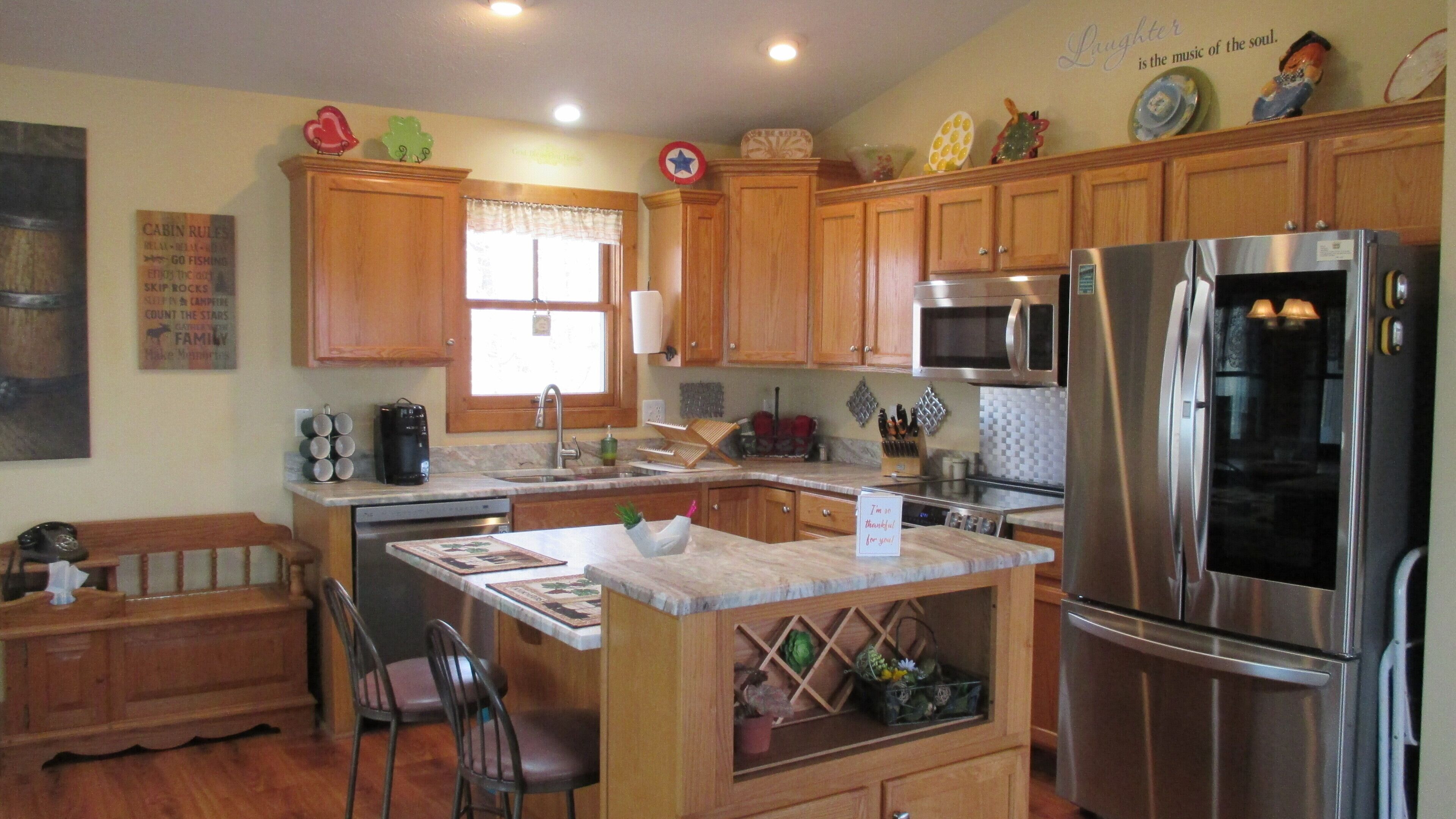 A kitchen with wooden cabinets, a stainless steel refrigerator, a microwave, and a coffee maker.