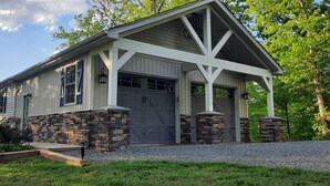 A two-story building with a garage, stone foundation, and a covered porch. - Beautiful waterfront lodge, private dock and breath taking views of Smith Mt. (Pittsville)