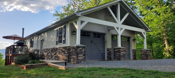 A two-story building with a garage, stone foundation, and a covered porch. - Beautiful waterfront lodge, private dock and breath taking views of Smith Mt. (Pittsville)
