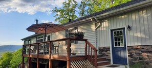 A two-story house with a balcony, a blue door, and a stone accent wall. - Beautiful waterfront lodge, private dock and breath taking views of Smith Mt. (Pittsville)
