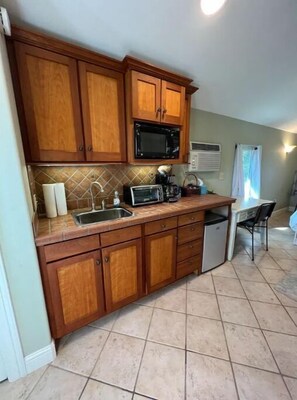 Kitchen area with sink, toaster, microwave, and refrigerator.