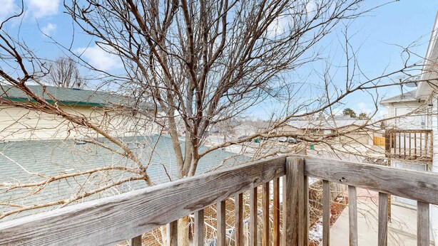 Une clôture en bois, avec des branches nues, et un ciel dégagé.