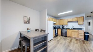 Une cuisine moderne avec des meubles en bois, un four encastré et un lave-vaisselle.