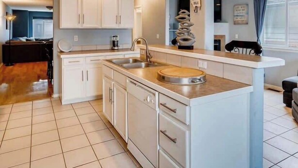 Een moderne keuken met witte kasten, een centraal eiland en een inbouwoven.